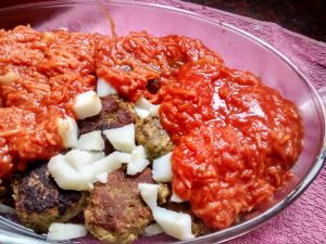 albóndigas lentejas con salsa, bañadas con salsa y cubos de papa