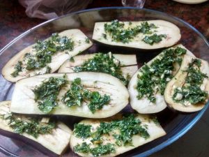 Berenjenas al horno, cortadas a la mitad, adobadas con hierbas